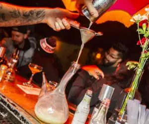 Cocktail straining into a porron